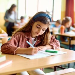 Schoolgirl,Writing,While,Learning,During,A,Class,In,The,Classroom.